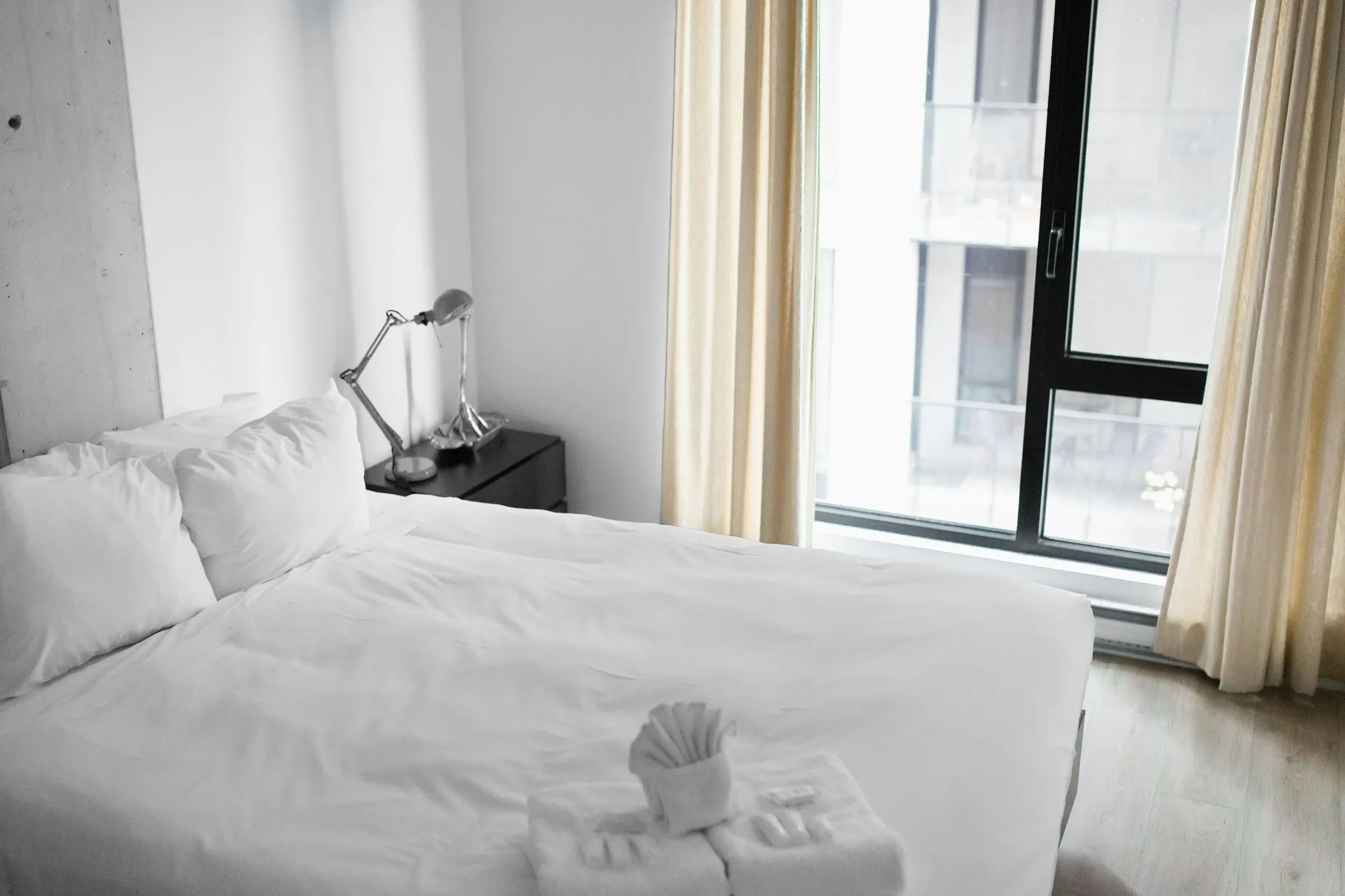 Minimal suite with white linen and soft daylight