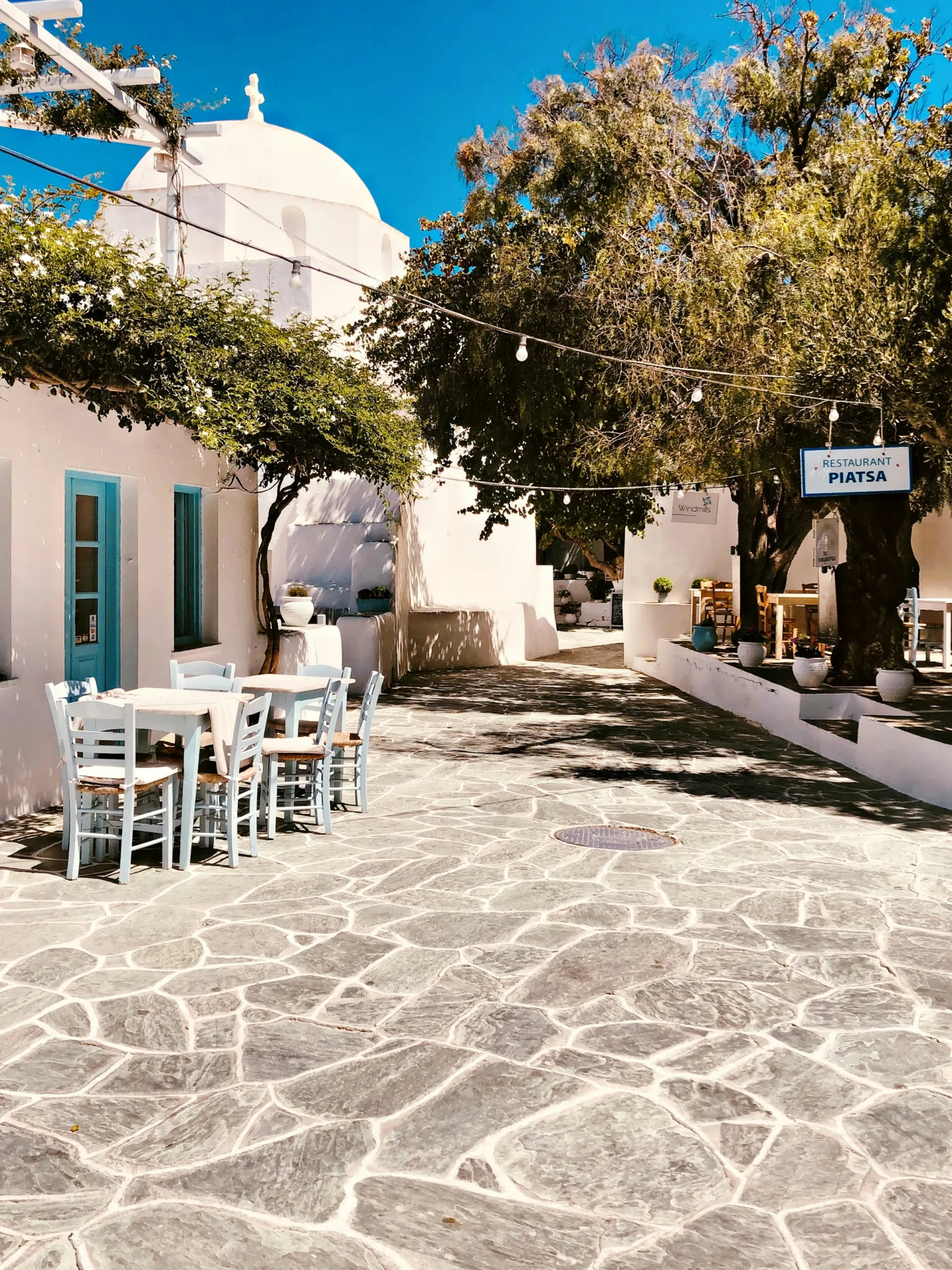 Paved village lane with whitewashed houses and trees