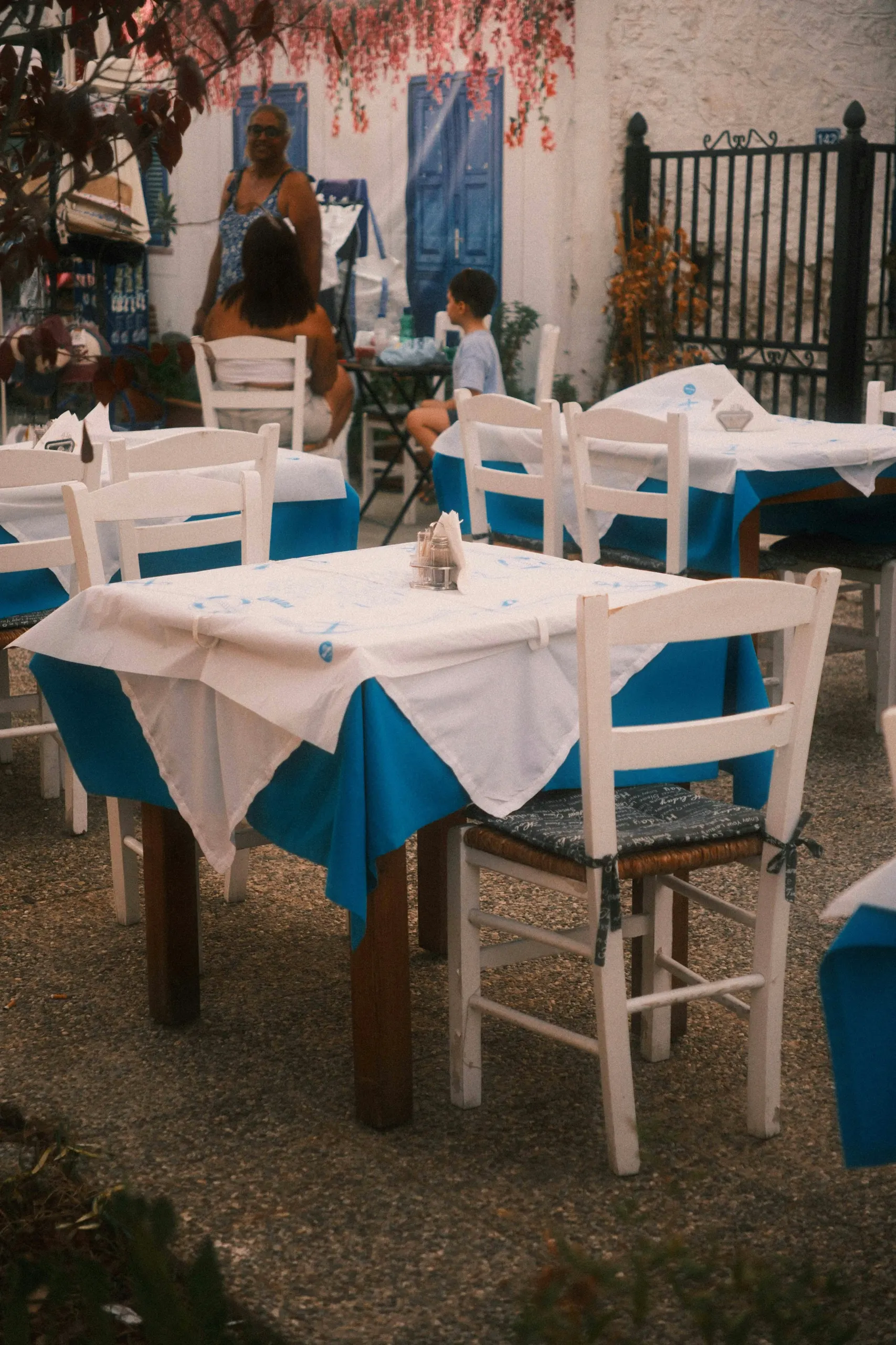 Tables laid with blue and white cloths in a village courtyard